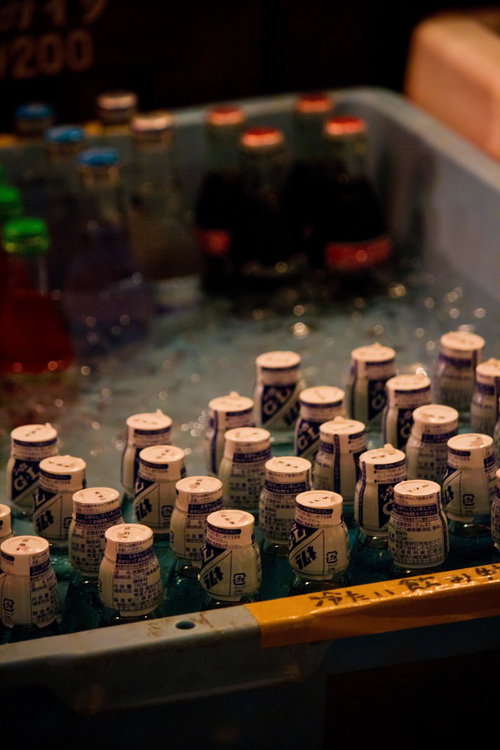 白いプラスチック容器に並べて冷やされたラムネの小瓶