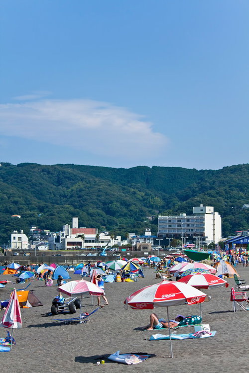 パラソルやテントが並ぶ真夏の賑わうビーチ