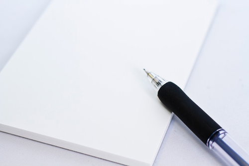 白い紙の上に斜めに置かれたメモ用のシャーペン