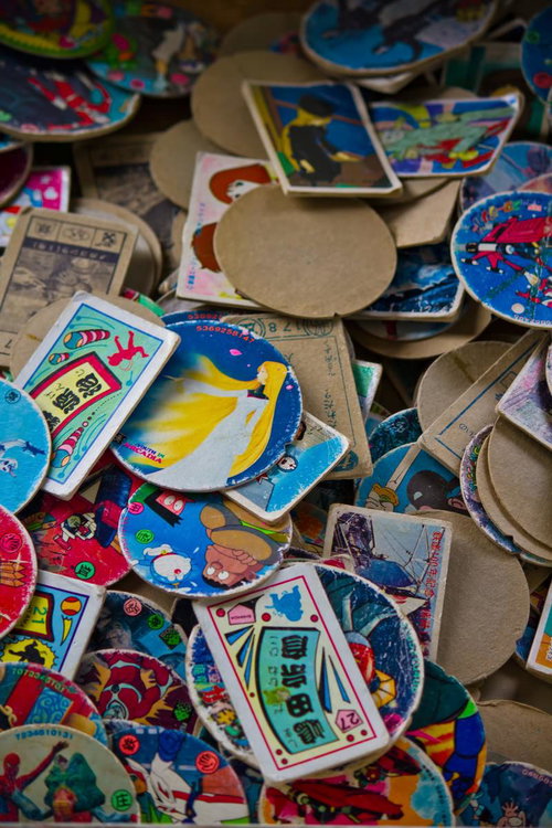 カラフルなイラストが描かれた懐かしい丸いメンコの山