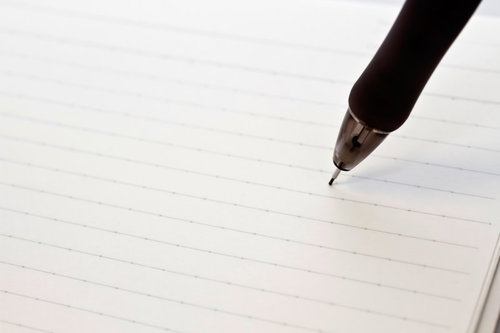 横線入りノートの紙面にペン先が触れる瞬間