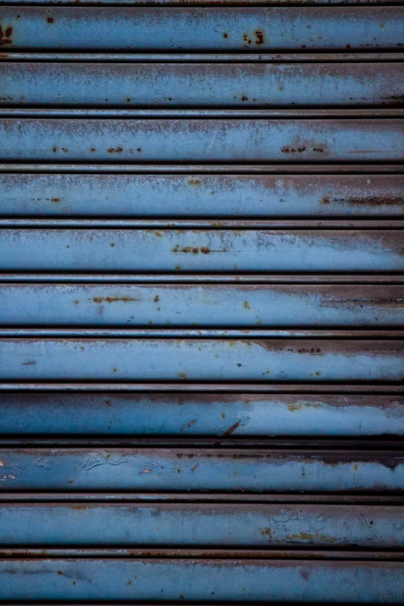 錆が浮いた青い金属シャッター