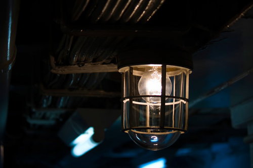 暗い天井から吊り下がる金色のかご型ランプ