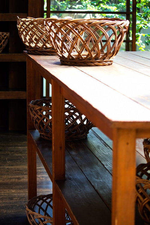 窓から緑が見える銭湯の脱衣所の編みカゴ