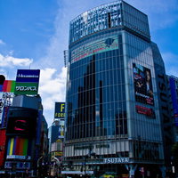 横断歩道越しに見上げる渋谷TSUTAYAのガラス張りビルの写真