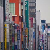 カラフルな看板が並ぶ新橋の駅前のビル群の写真