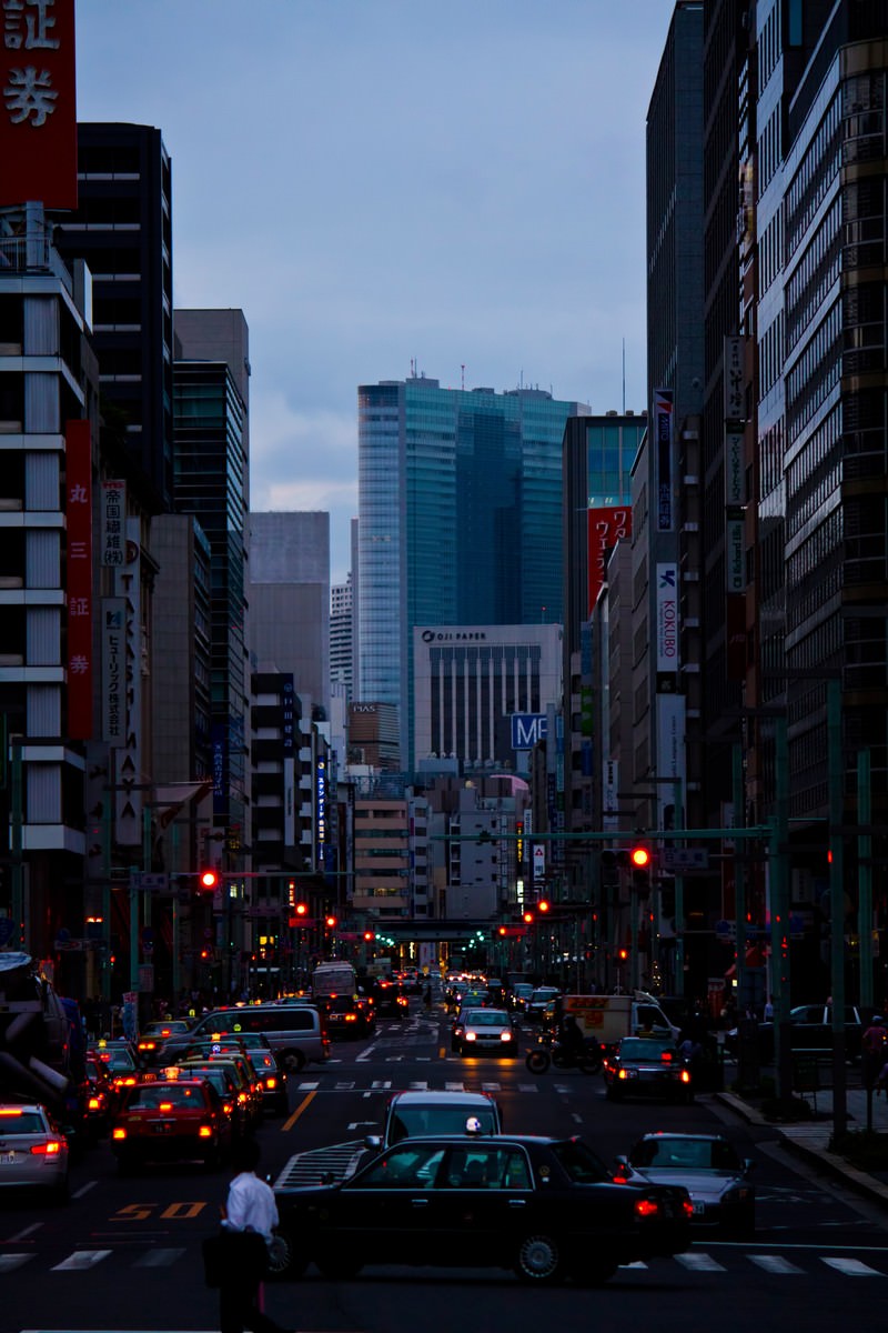テールランプが光る夕方の日本橋のオフィス街と車