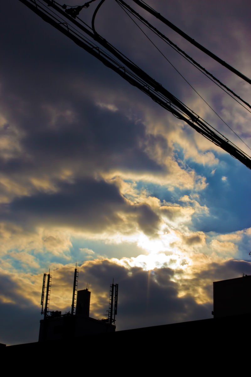 雲の切れ間から光が差す夕暮れの空
