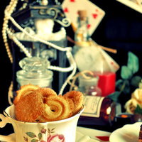 花柄カップに入ったクッキーとアリスのお茶会風セットの写真