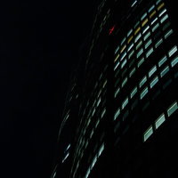 夜に明かりが灯る六本木ヒルズの高層ビルの写真