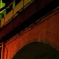 夜に照らされた赤レンガのアーチ状のガード下の写真