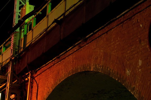夜に照らされた赤レンガのアーチ状のガード下