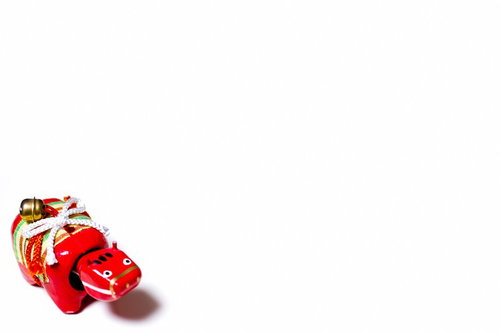 鈴と飾り紐がついた赤べこ一匹