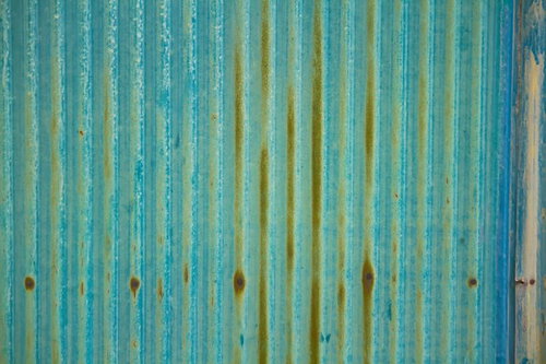 青と黄色の縞模様が塗られた古いトタン板