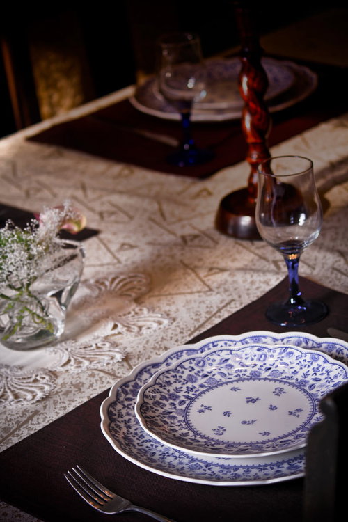 青い花柄の皿とワイングラスのテーブルセッティング