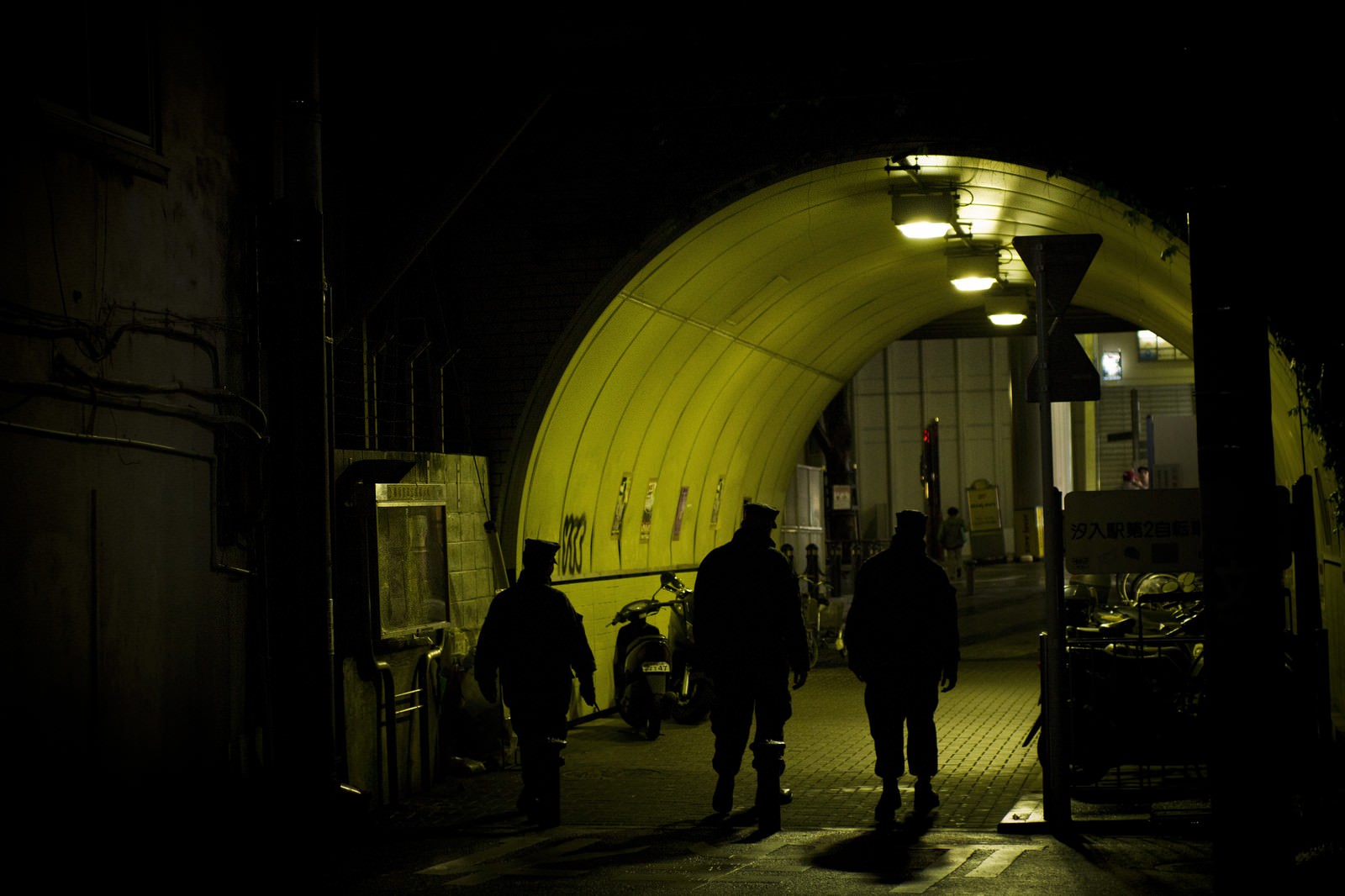 夜の通路を歩く人々のシルエット