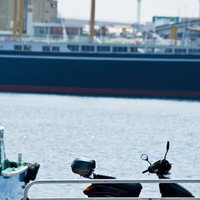 埠頭に停めた黒いスクーターの写真