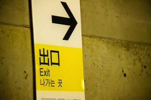 駅の壁に設置された出口への黄色い案内板