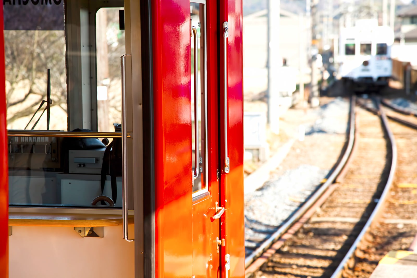 赤い電車のドアと奥へ伸びる線路