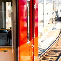 赤い電車と線路のある駅風景の写真