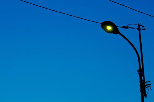 薄暗い夕暮れの青空に灯る街灯