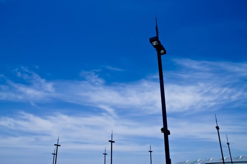 青空に向かって立つ街灯のポール