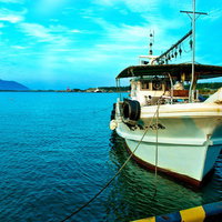 桟橋に係留された漁船と青空の写真