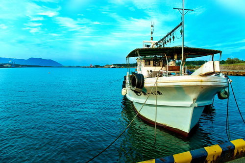 桟橋に係留された漁船と青空