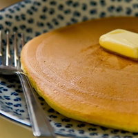 バターをのせた丸いホットケーキの写真