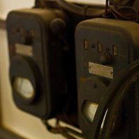 暖色の照明に照らされた古い機械の電圧計の写真