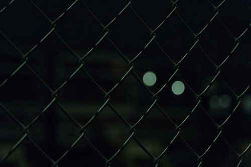 夜の金網越しに見える光