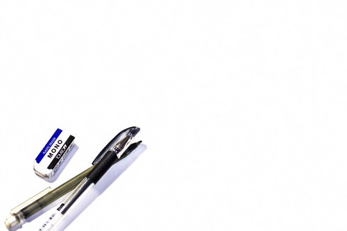 白い机の上のMONO消しゴムと2本のペン