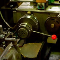 工房に置かれた金属製の小型旋盤の写真