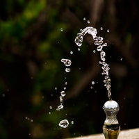 公園の水飲み場から噴き出す水の写真