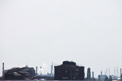 曇り空の下に煙突が並ぶ工業地帯の工場