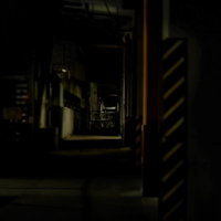 夜の高架下に続く工場通路の写真