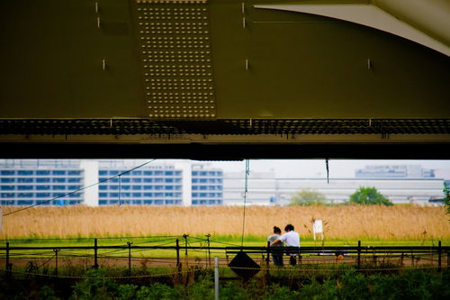 高架下のベンチで語らう恋人達