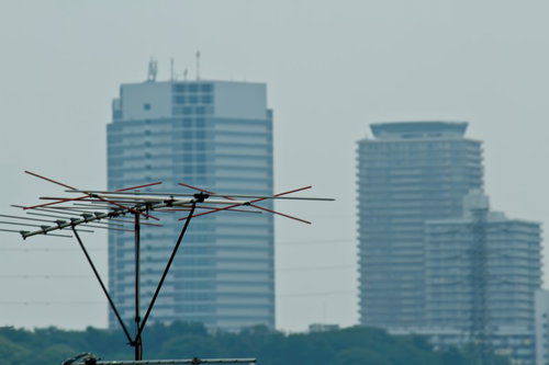 曇り空の高層ビルと手前のテレビアンテナ