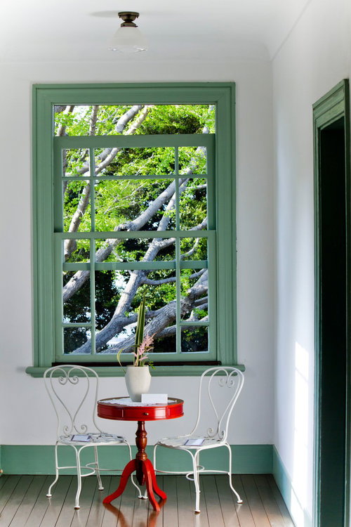 窓辺の赤い丸テーブルと白い椅子