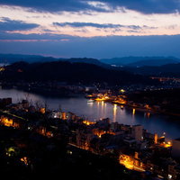 高台から見下ろす朝焼けの尾道の港の写真