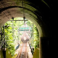 ケーブルカーの線路が続くトンネルを抜ける光景の写真