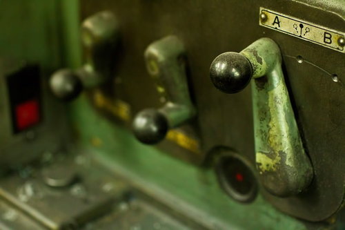 汚れと錆が残る汎用旋盤の緑のレバー