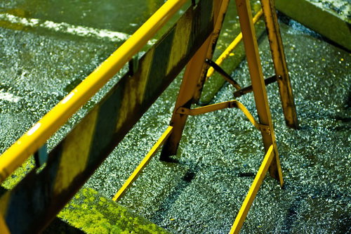 濡れた地面に置かれた黄色い遊具と立ち入り禁止の看板