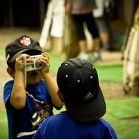 屋外で写真を撮り合う子供の兄弟の写真