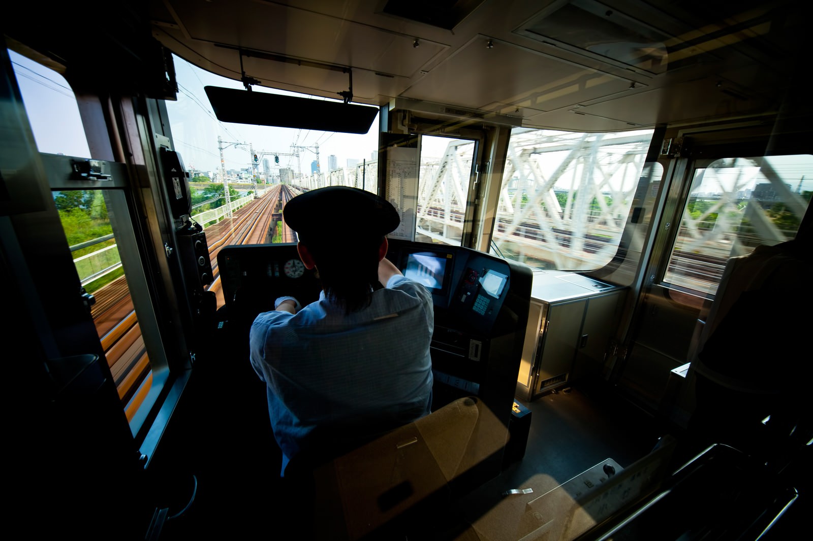 運転室で運転台の前に座る車掌