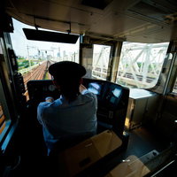 電車を運転中の車掌と前方の線路の写真