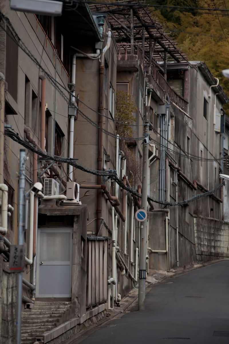 電線が横切る古い建物が並ぶ路地