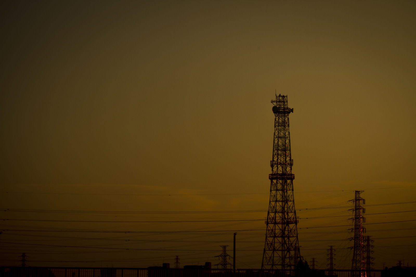 夕方の空に立つ鉄塔と送電線