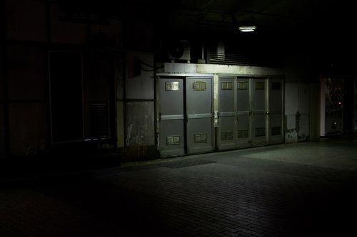 照明に照らされる薄暗い通路の扉