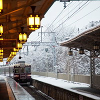雪に覆われた駅ホームを通過する電車の写真
